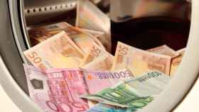 Dinero: billetes de euros 'lavados' en una lavadora, en un ejemplo de corrupción