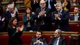 El presidente de la Generalitat, Quim Torra (d), es aplaudido por los miembros de su partido mientras que su vicepresidente, Pere Aragonés (i), y los diputados de ERC permanecen sentados / EFE