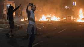 Un joven se hace un selfi ante una barricada en llamas durante los disturbios del independentismo violento en Barcelona / EFE