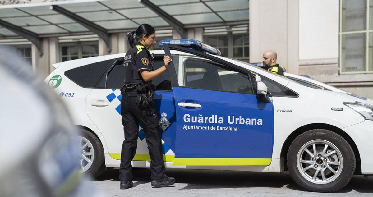Una agente de la Guardia Urbana de Barcelona entra en un coche patrulla / Aj. BCN