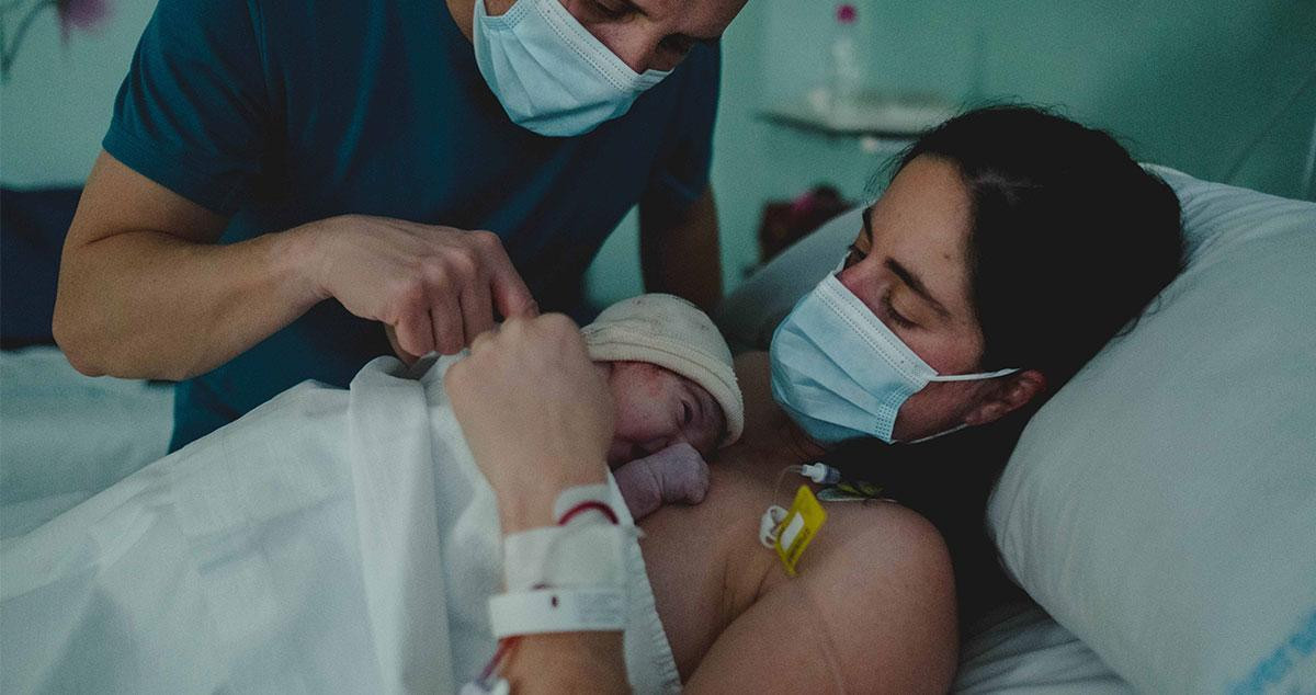 Una mujer observa a su bebé tras un parto / CG