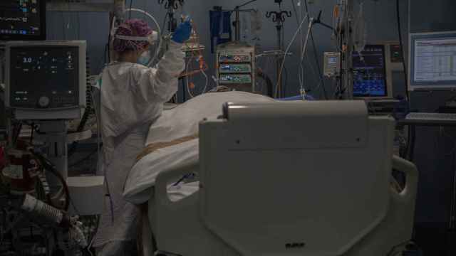 Una sanitaria atiende a uno de los pacientes que permanecen ingresados en las ucis de Cataluña / DAVID ZORRAKINO (EUROPAPRESS)