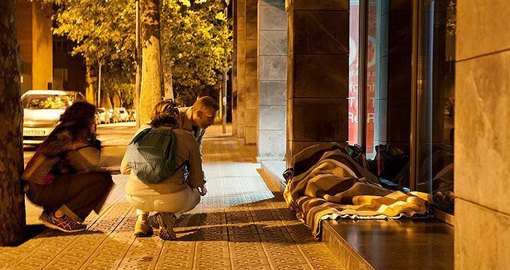 Miembros de Arrels Fundació se acercan a una persona que duerme en la calle / ARRELS FUNDACIÓ