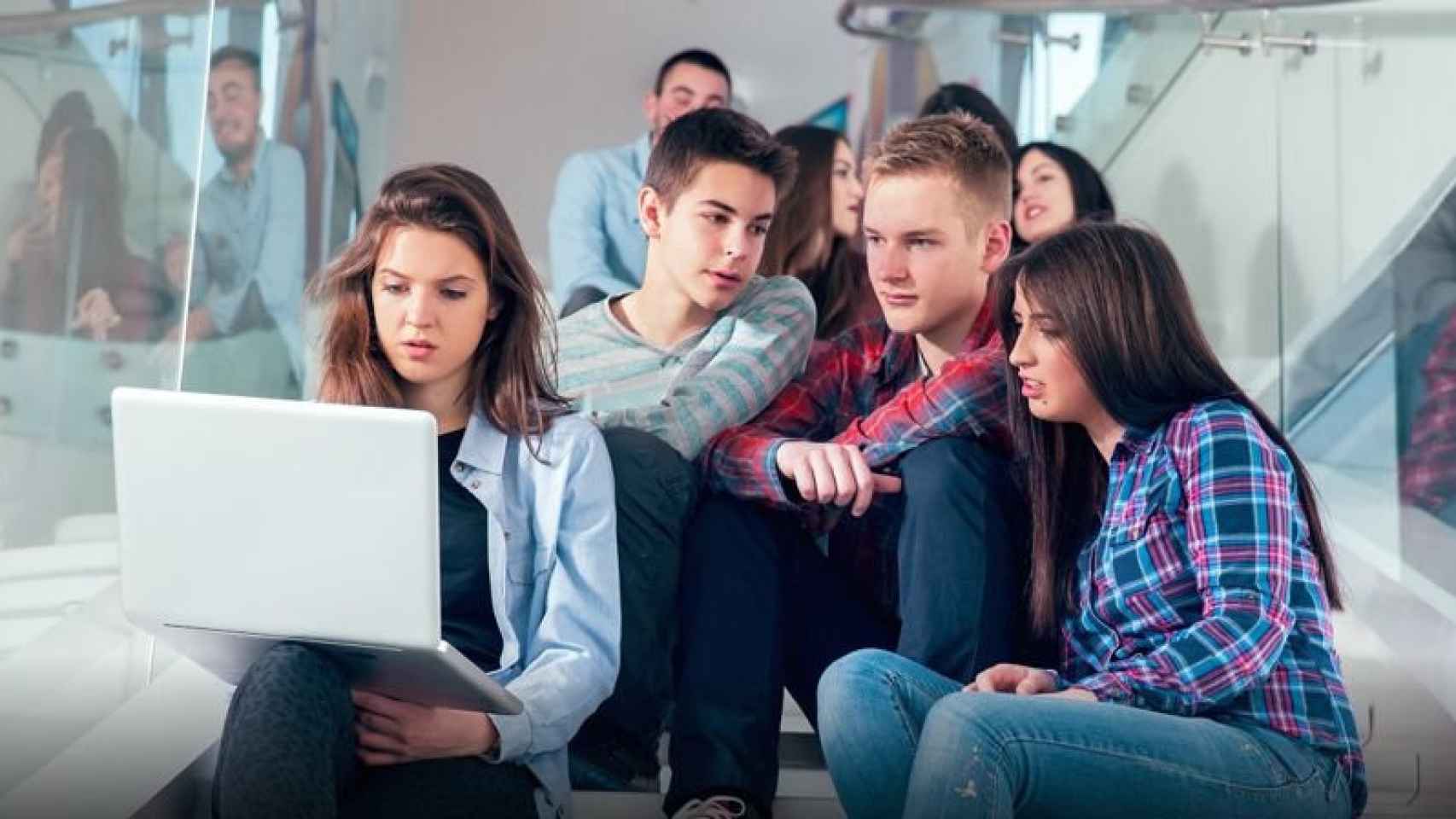 Un grupo de adolescentes miran la pantalla de un ordenador.