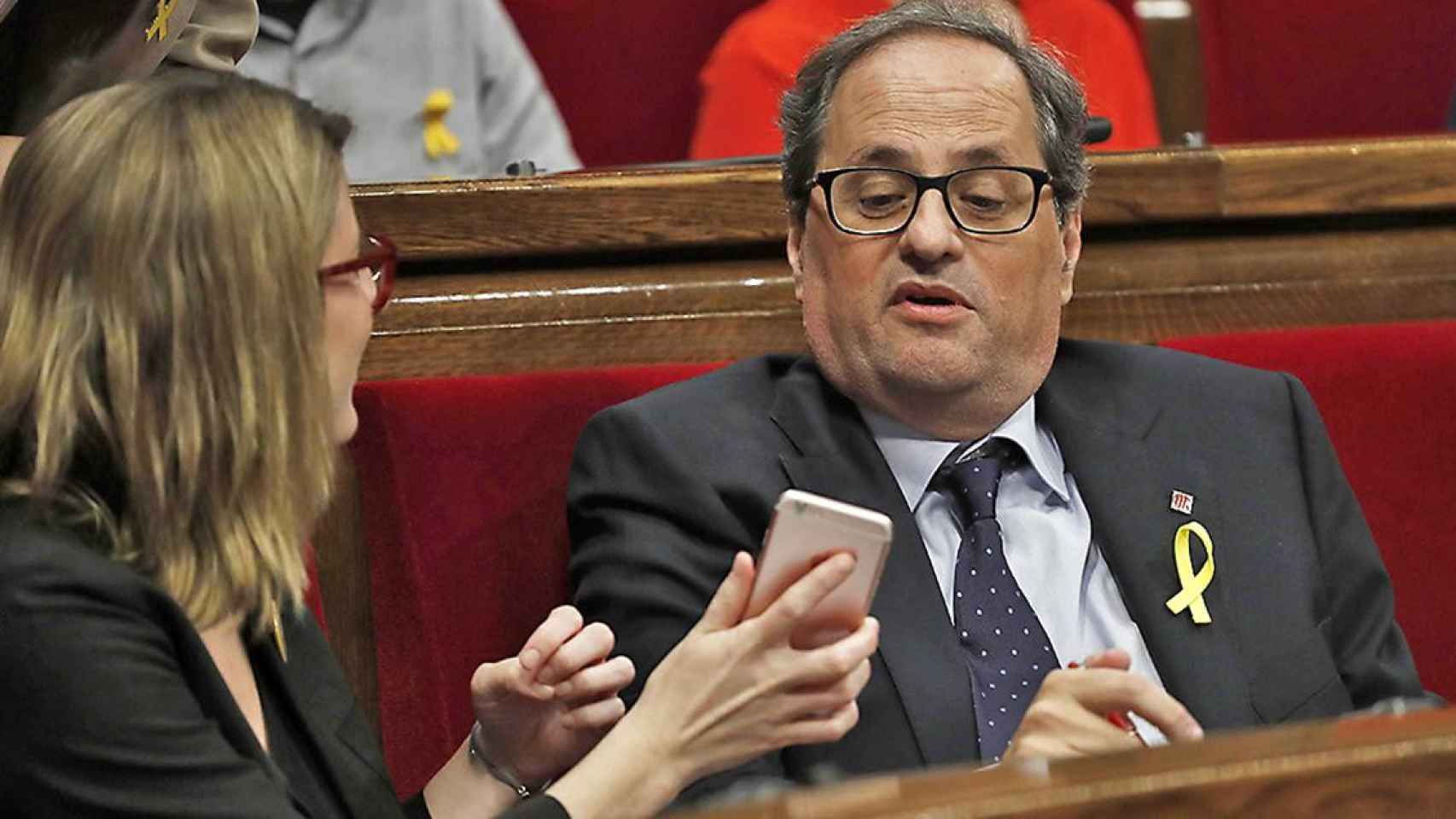 Quim Torra mira el móvil que le muestra Elsa Artadi en el Parlament / CG
