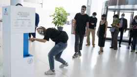 Visitantes del CaixaForum de Barcelona se aplican gel hidroalcohólico antes de acceder al centro / EP