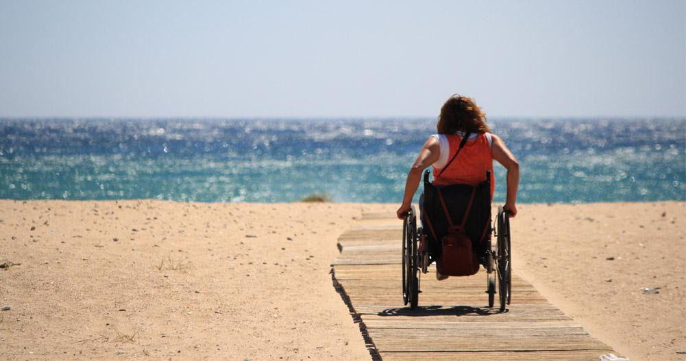 Una mujer en silla de ruedas visitando la playa en Cataluña / M.PEINADO - WIKIMEDIA COMMONS