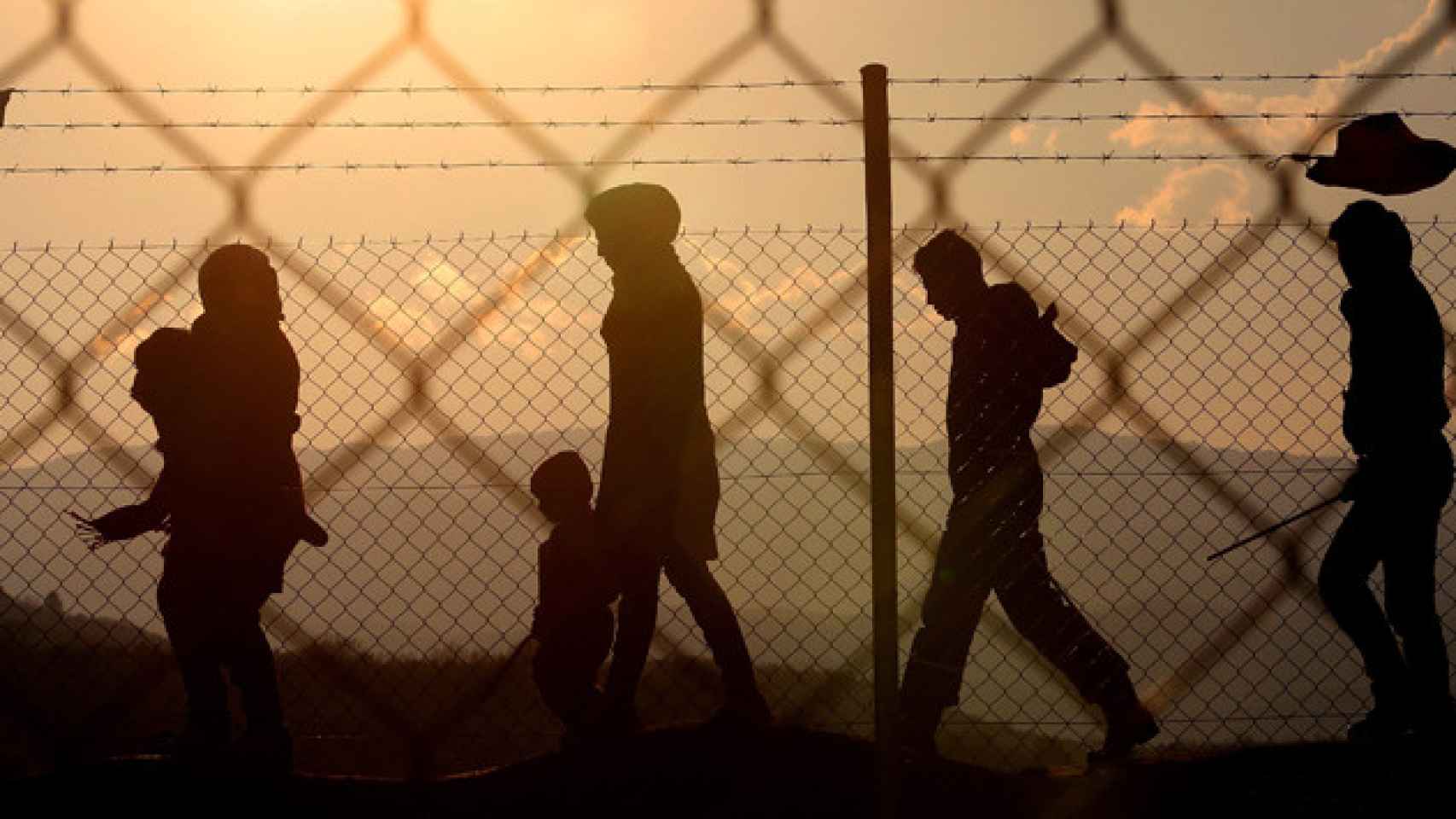 Inmigrantes caminan junto a una valla cerca del campo de refugiados de Idomeni (Grecia) / EFE