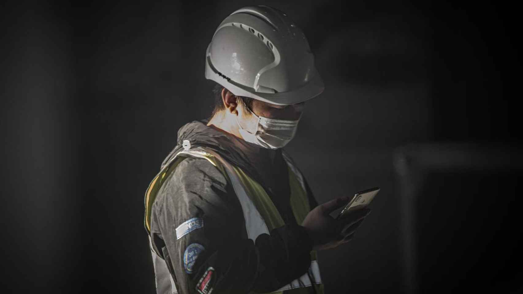 Un trabajador asiático con mascarilla en el pabellón del Mobile durante el desmantelamiento de los stands / EUROPA PRESS