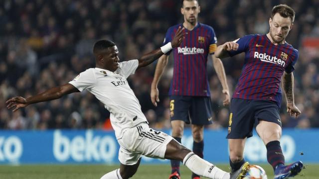 Ivan Rakitic intentando un pase delante la presión de Vinicius / EFE