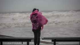 Una mujer contempla desde el paseo marítimo de Barcelona el temporal de viento y oleaje /EP