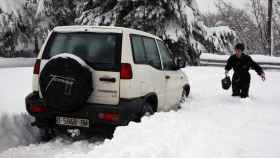 Un coche intenta circular por la nieve en una carretera de Asturias / EFE