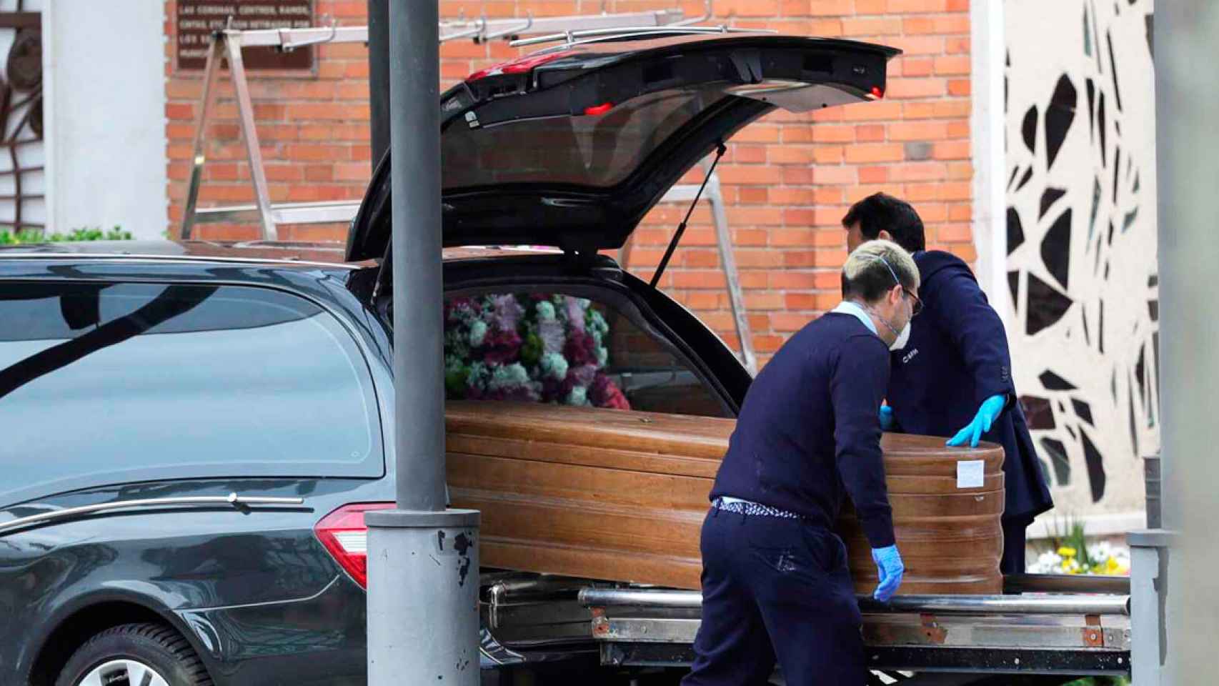 Dos trabajadores funerarios de la empresa municipal de Madrid, manipulando una caja / EFE