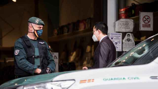 Un agente vigila durante uno de los registros en un polígono de Madrid en una operación contra la mafia china / EP