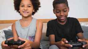 Dos hermanos se divierten con un videojuego en el salón de su casa /  FREEPIK