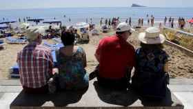 Dos parejas de viajeros mayores contemplan la playa de Benidorm, en un viaje de la Imserso / CG