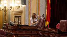 Una empleada del Congreso rapasa las butacas de la presidencia de la Cámara pocas horas antes de que comience el debate de investidura.