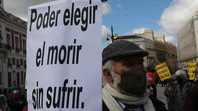 Un hombre con un cartel en el que se lee: Poder elegir el morir sin sufrir durante una concentración de Derecho a Morir Dignamente en la Puerta del Sol, en Madrid (España), a 18 de marzo de 2021 / MARTA FERNÁNDEZ - EUROPA PRESS