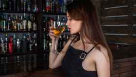Imagen de archivo de una mujer en la barra de un bar / PIXABAY