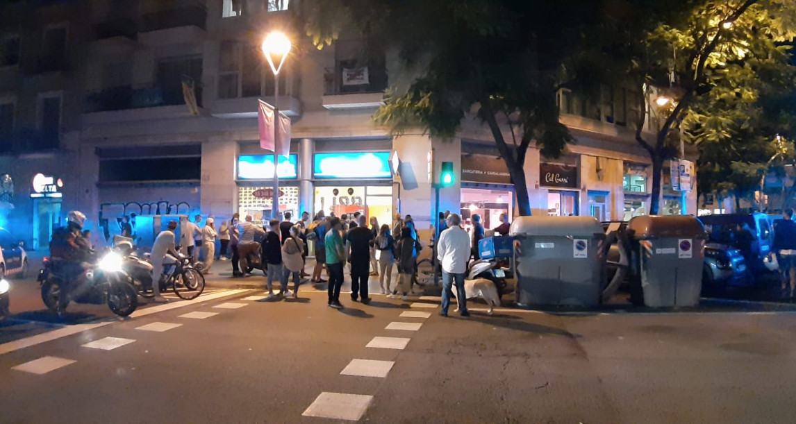 Curiosos se concentran junto a la pizzería de la calle Sicilia de Barcelona en la que se ha atrincherado un hombre con un cuchillo / CG
