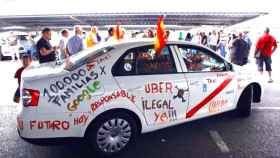 Un taxi con pintadas de protesta contra Uber, en una de las manifestaciones / EFE