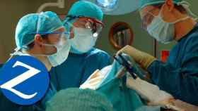 Un grupo de cirujanos en un quirófano junto al logo de Zurich / FOTOMONTAJE CG