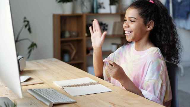 Una niña utiliza su ordenador para hacer una videollamada / PEXELS