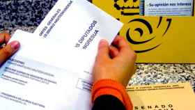 Imagen de archivo de la mano de una ciudadana que deposita su voto por correo en una oficina / EFE
