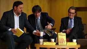 Oriol Junqueras (i), Carles Puigdemont (c) y Artur Mas (d), pendientes del adelanto electoral, en la presentación de un libro / EFE