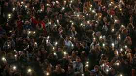 Cientos de personas iluminan sus teléfonos durante una vigilia por las víctimas de París en la plaza del Capitolio en Toulouse