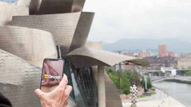 Una persona abre la app Grindr delante del Guggenheim de Bilbao / FOTOMONTAJE DE CG