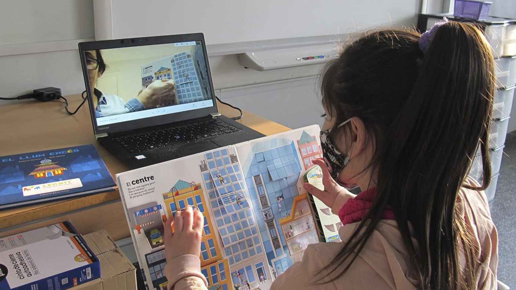 Una niña y un voluntario comparten lectura en el marco del programa de CaixaBank / EP