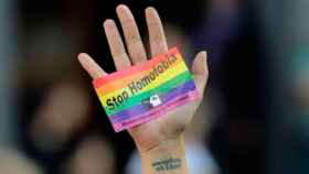 Una mano sujeta un cartel que condena la homofobia / EFE