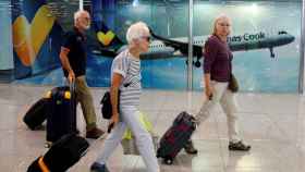 Varios turistas caminan frente al mostrador de Thomas Cook en el Aeropuerto de Mallorca / EFE