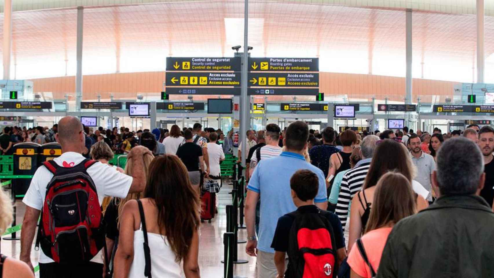 Imagen de pasajeros ante los filtros de seguridad del aeropuerto de El Prat, cuyos vigilantes están en huelga indefinida / EFE