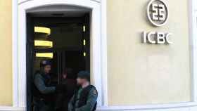 Agentes del UCO custodian la entrada de la oficina del banco chino ICBC en Madrid.
