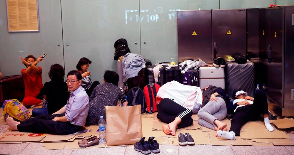 Turistas 'tirados' por la demora en su vuelo debido al asedio independentista del aeropuerto de Barcelona-El Prat / EFE