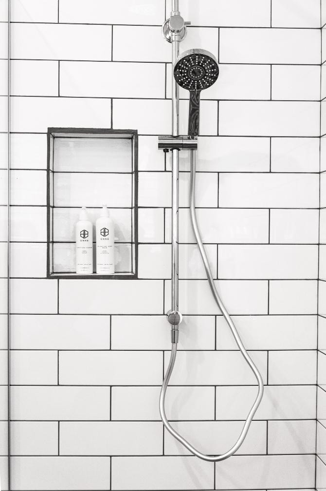 Imagen de una ducha con champús en un soporte/ Onne Beauty en UNSPLASH