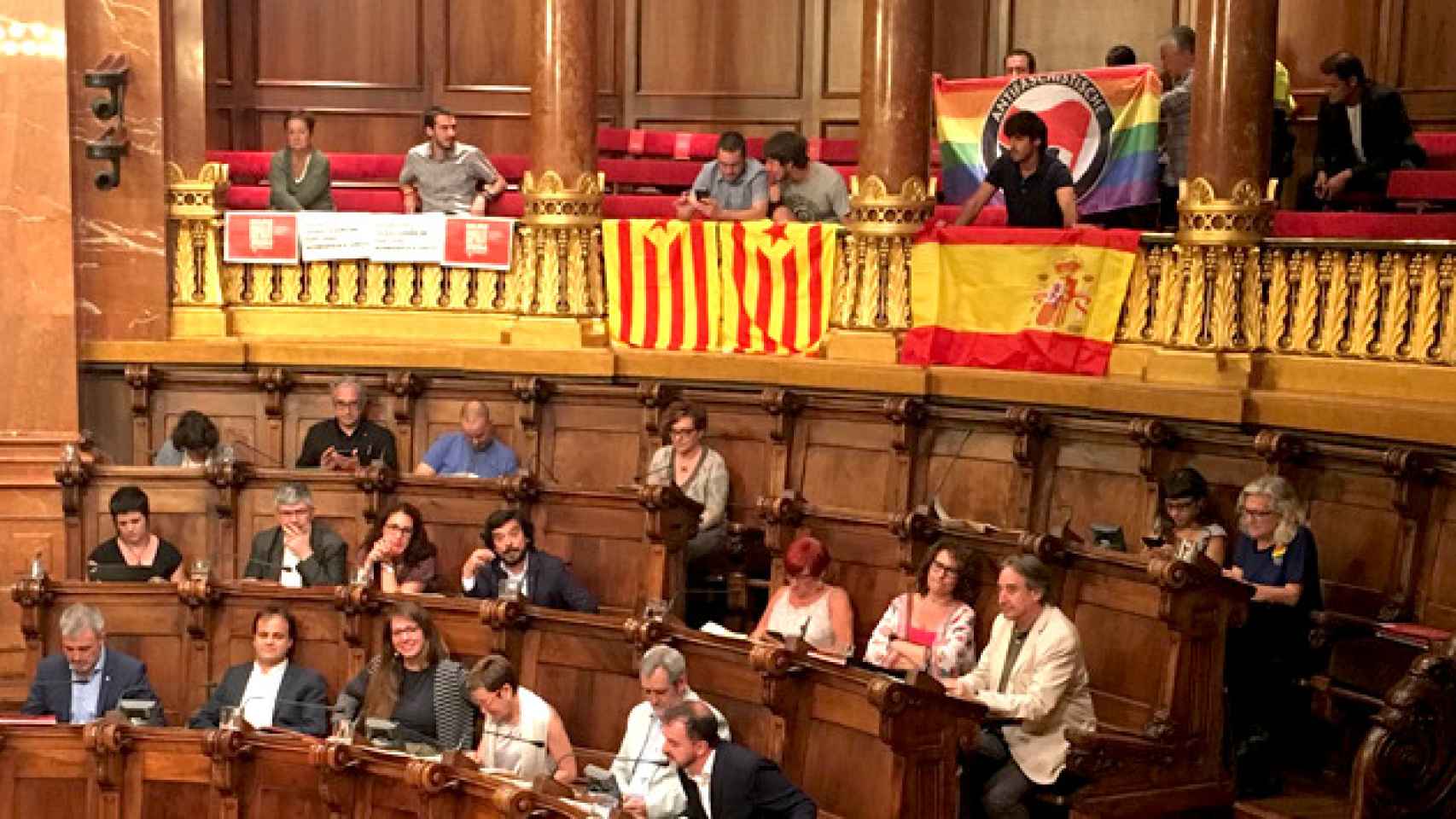 Banderas de España y Cataluña desplegadas por los asistentes en el pleno municipal de junio / CG