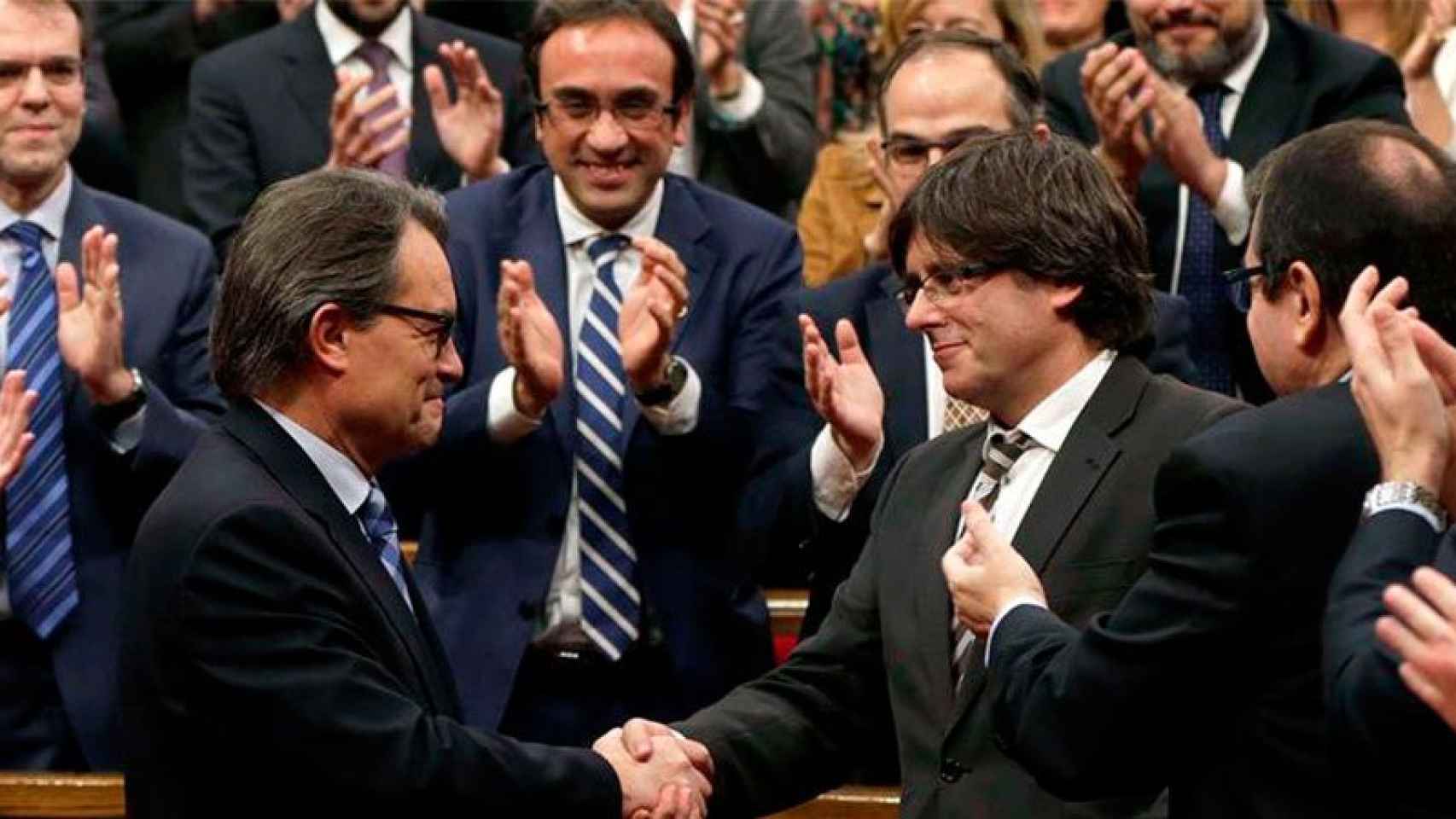 Un Artur Mas emocionado felicita a su sucesor, Carles Puigdemont, tras la votación de investidura.