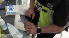 Un agente de la policía nacional analiza la cocaína incautada en uno de los laboratorios desmantelados en Barcelona / CNP