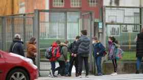 Padres y alumnos esperan a las puertas de un colegio protegidos contra el Covid con mascarillas: los escolares en cuarentena vuelven a aumentar ligeramente / EP