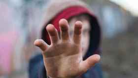 Un menor con la mano en alto para ilustrar el rechazo a los abusos / EFE