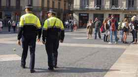 Dos agentes de la Guardia Urbana patrullan en la Plaza de Sant Jaume, frente al Ayuntamiento de Barcelona / EP