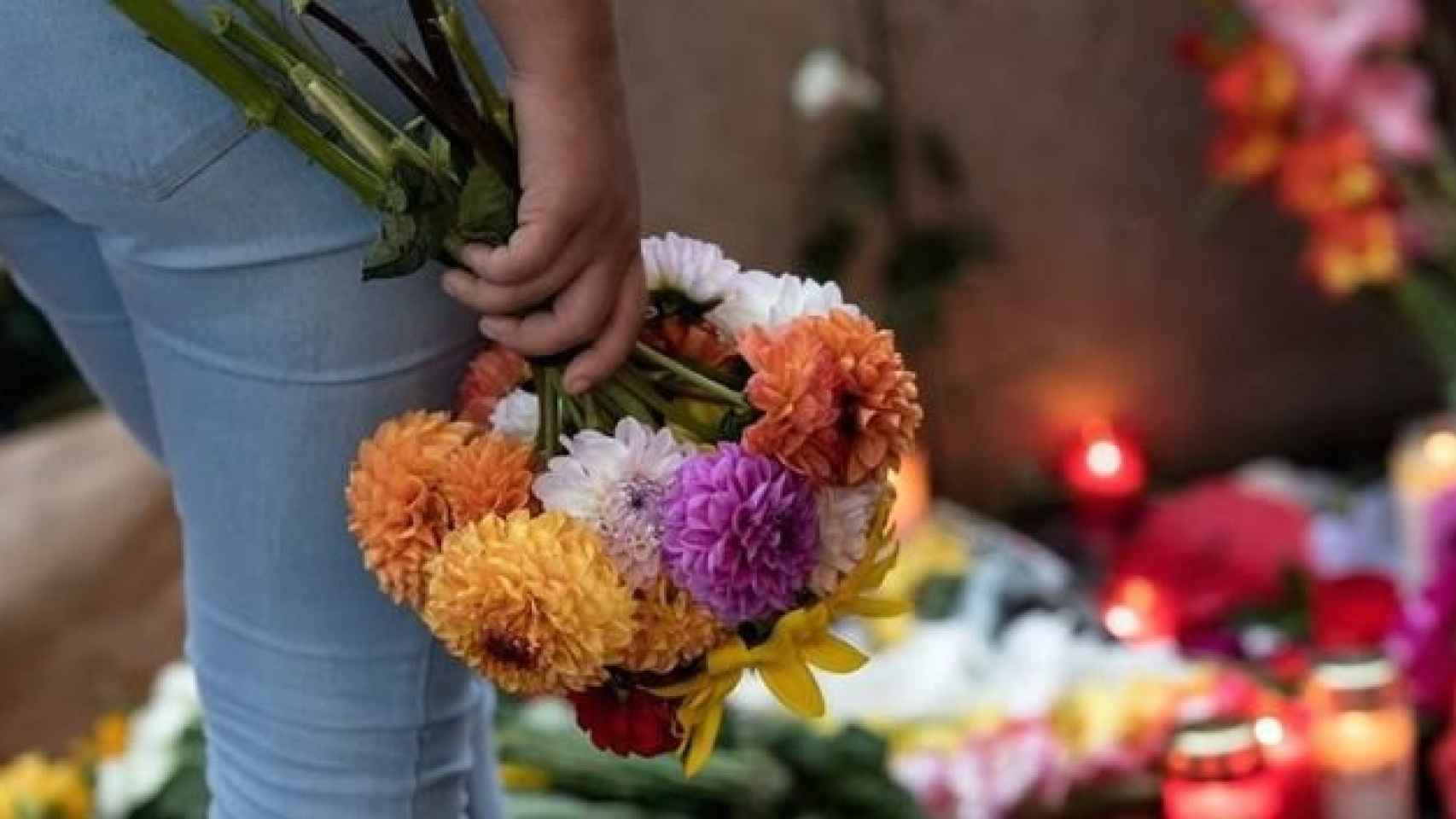 Una ciudadana muestra sus condolencias con un ramo de flores por las víctimas de la masacre en Múnich.