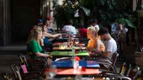 Varias personas sentadas en una mesa en la plaza Real de Barcelona este verano, en una imagen de archivo / DAVID ZORRAKINO - EUROPA PRESS