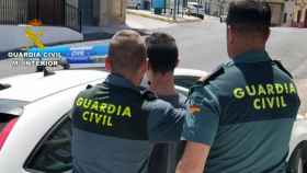 Una pareja de la Guardia Civil mientras detienen a un joven en una imagen de archivo / M. INTERIOR
