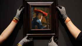Dos operarios cuelgan la tabla Mujer con el sombrero rojo (1664-1667) en una de las salas del Rijksmuseum. RIJKSMUSEUM / KELLY SCHENK