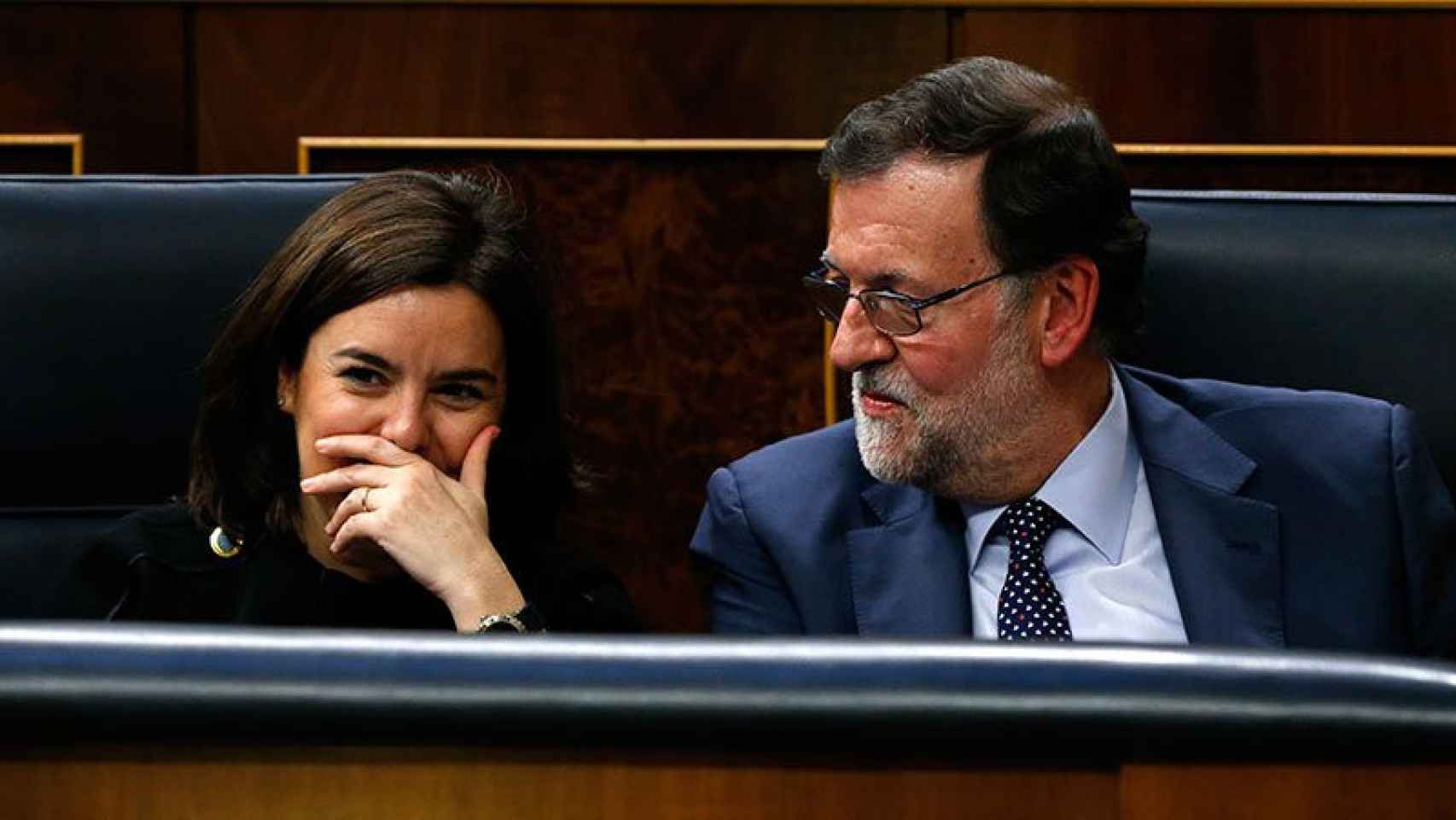 La vicepresidenta Soraya Sáenz de Santamaría ríe durante la primera sesión de investidura bajo la mirada de Mariano Rajoy.