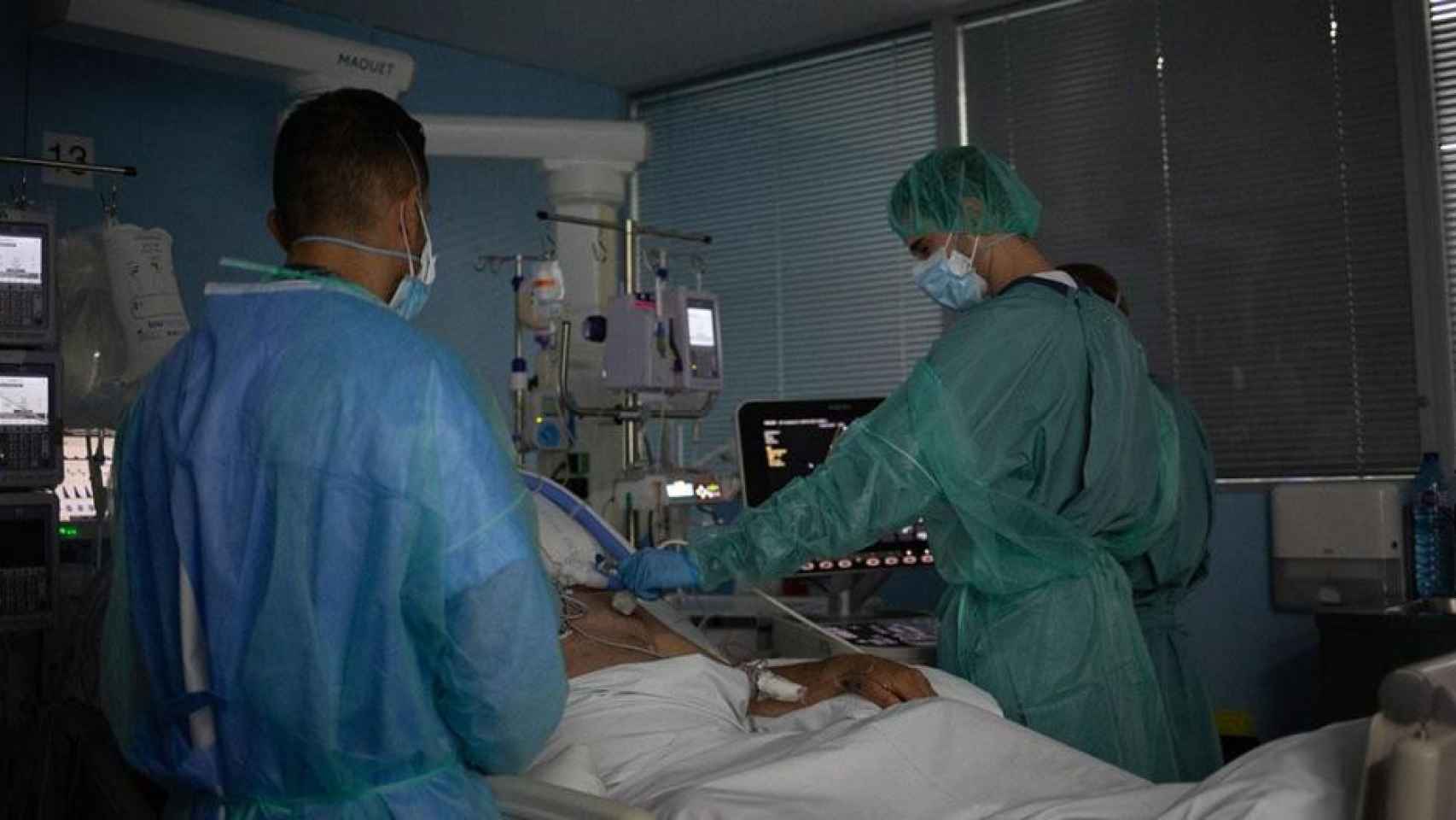 Personal sanitario visita a uno de los pacientes Covid ingresados en la uci del Hospital de la Santa Creu i Sant Pau de Barcelona / David Zorrakino (EP)